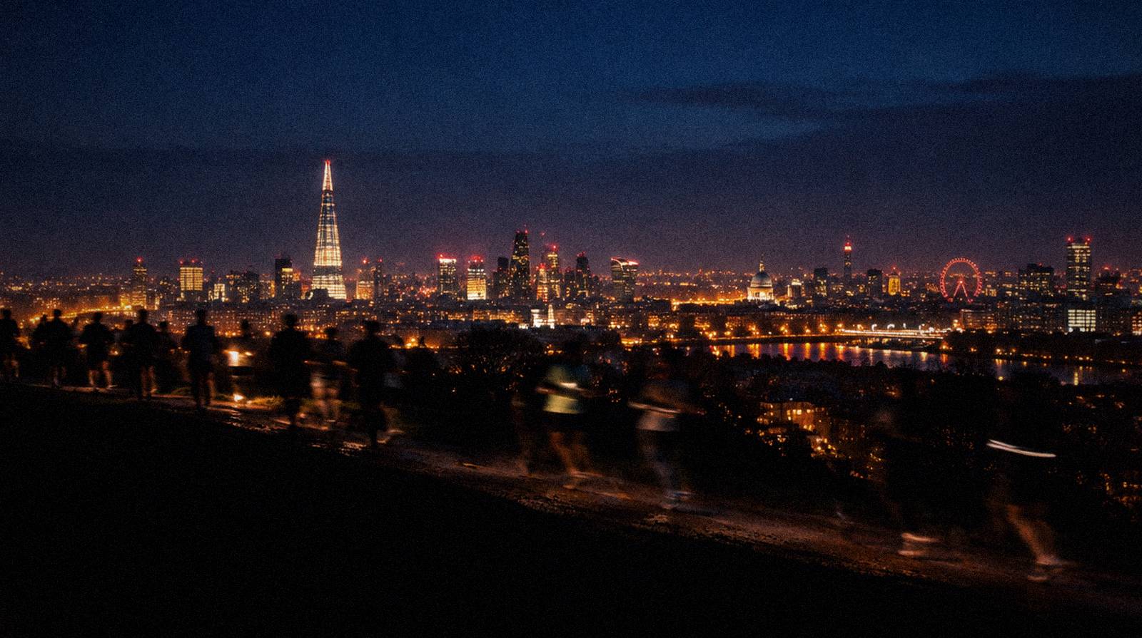 London skyline at night with walkers on the ridge